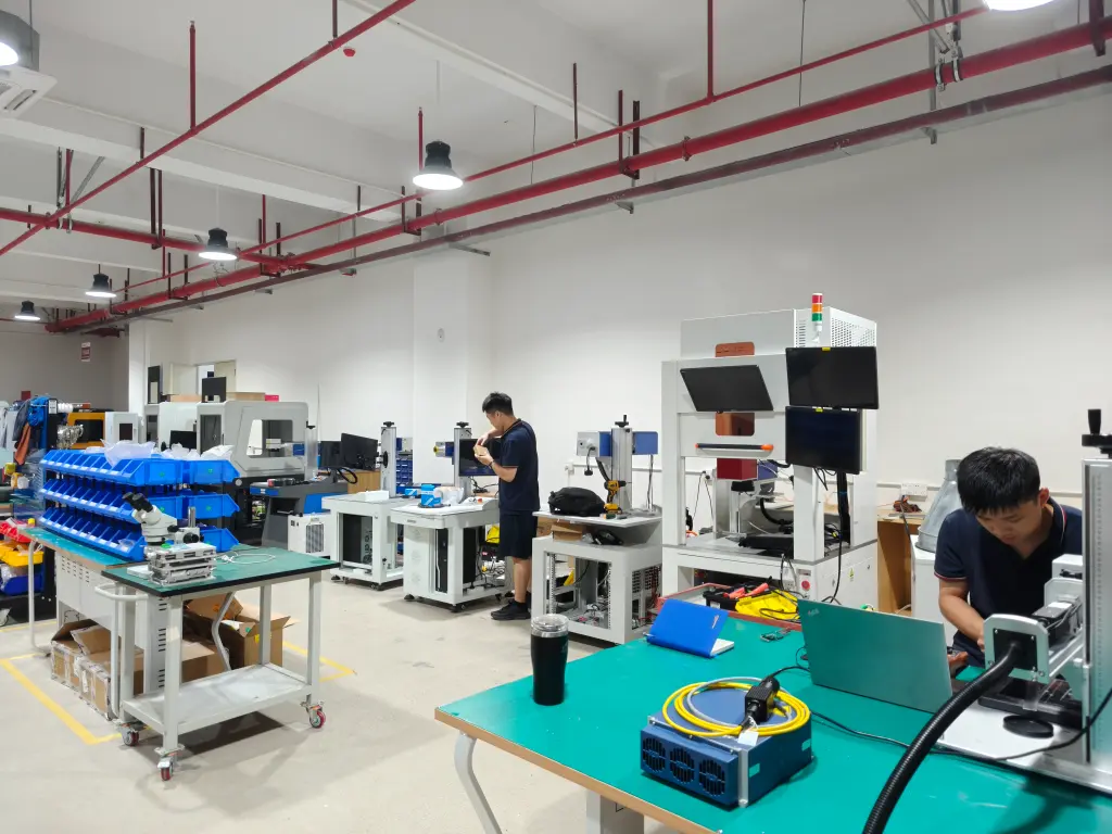 Visitors and a Hispeed Laser team member beside a laser marking machine in the workshop