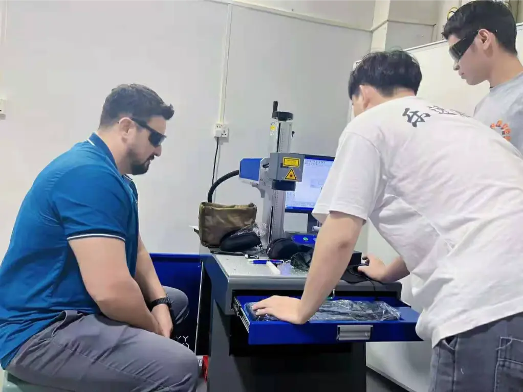 Visitor and Hispeed Laser technician observing an on-site laser marking sample test